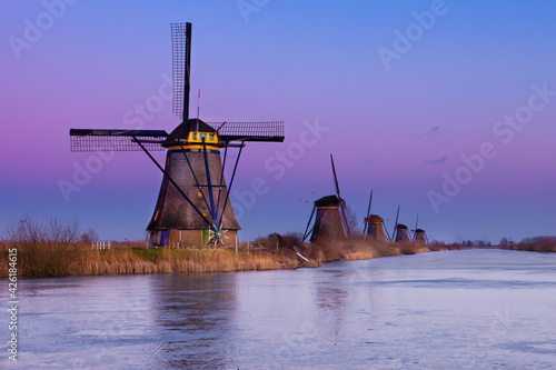 Quadro em tela Windmills at Kinderdijk, close to Rotterdam in The Netherlands, in winter with ice on canal at sunset