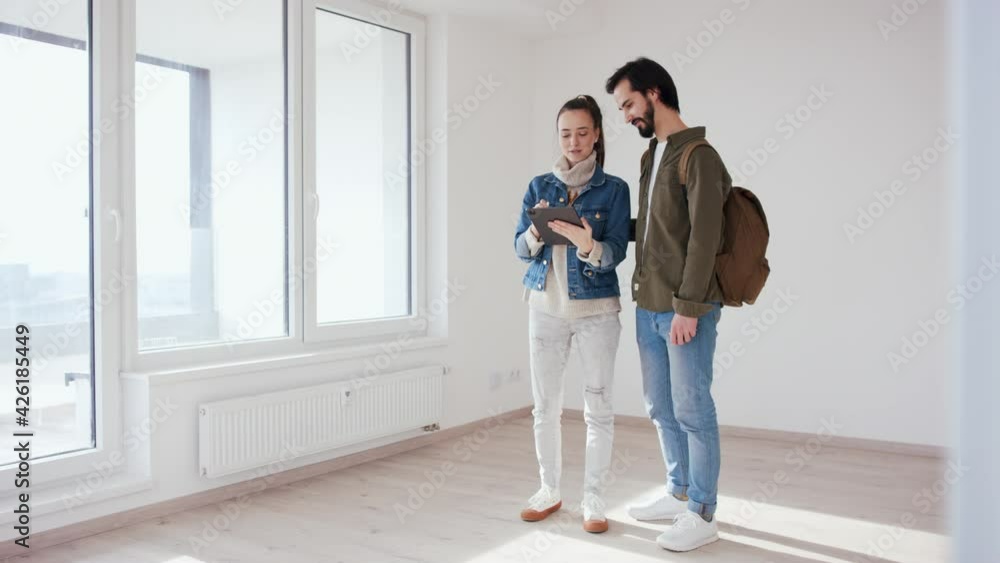 Young couple with tablet moving and planning in new flat, new home and relocation concept. Young couple with tablet moving and planning in new flat, new home and relocation concept.