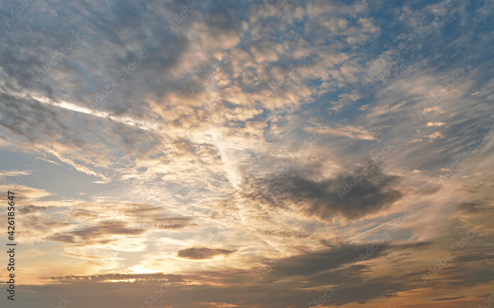 Fototapeta premium Morning blue orange sky, sun shining through clouds