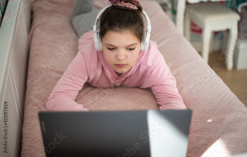 dziewczynka uczy się w swoim pokoju podczas nauki zdalnej photo