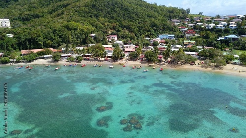 Aerial view of a white sand beach with boats in the bay in Martinique