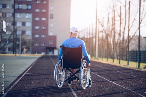Slika na platnu Rear view of a athlete sitting on a wheel chair on the athletic track