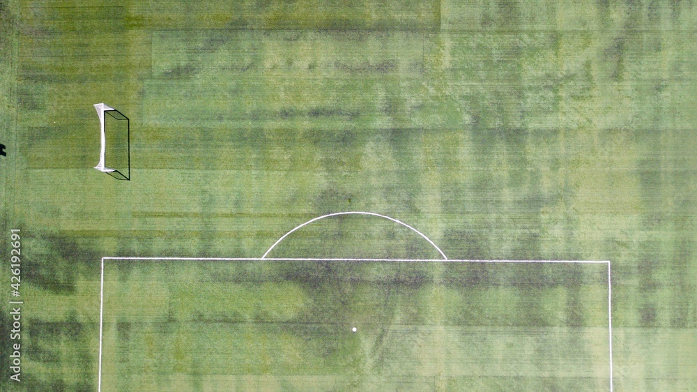 Aerial view of soccer football field. Mini goal post can be seen. People are walking on the jogging track. Aerial view of soccer football field. Mini goal post can be seen. People are walking on the jogging track.