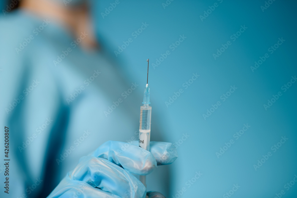 A nurse holds a syringe in her hands.Close-up A nurse holds a syringe in her hands.Close-up
