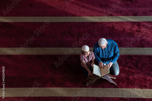 Canvas Print father and son reading holly book quran together islamic education concept