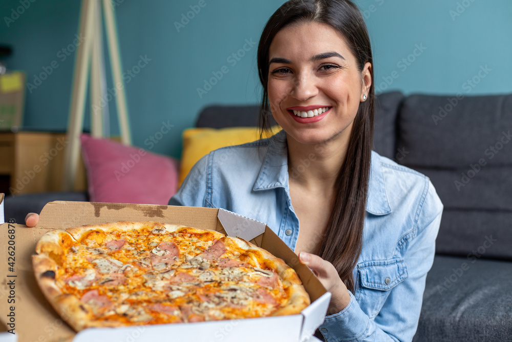 Portrait of young smiling woman eating pizza at home Portrait of young smiling woman eating pizza at home