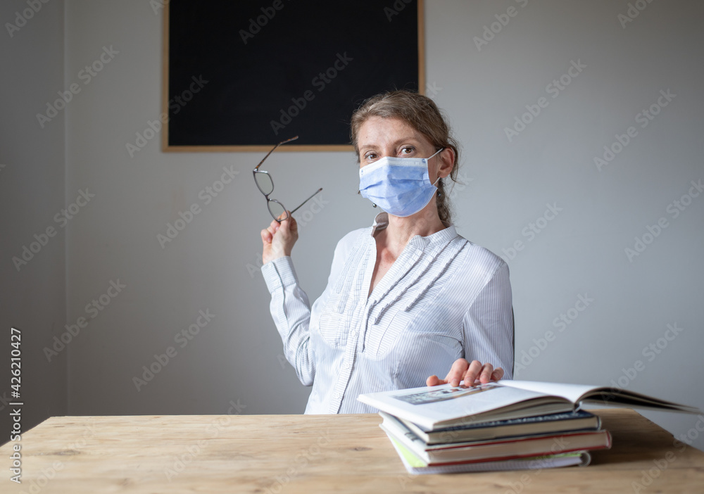 teacher in classroom wearing a medical mask school reopening