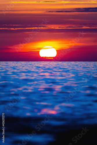 Fototapeta Naklejka Na Ścianę i Meble -  Colorful sunset with large bright sun under the sea surface. Sea sunset, ocean sunrise, seascape.