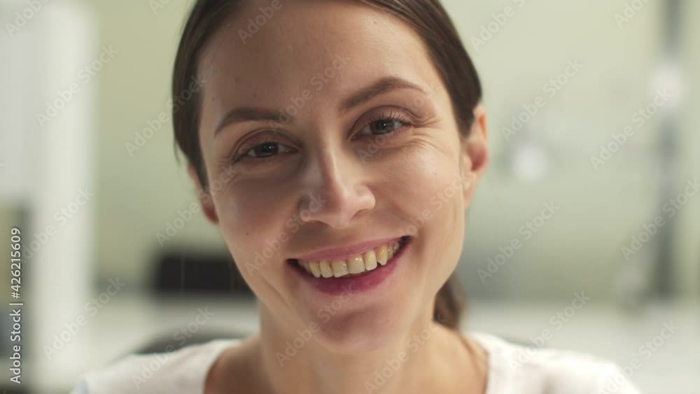 A close-up portrait of a smiling and laughing woman in a white T-shirt A close-up portrait of a smiling and laughing woman in a white T-shirt