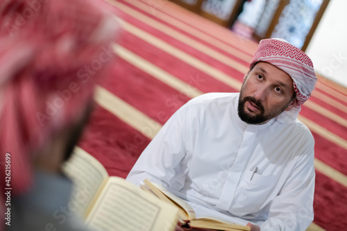 two muslim people in mosque reading quran together concept of islamic education