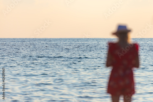 Blurred figure of a girl on the background of the sea. The endless blue sea and the man looking at it.