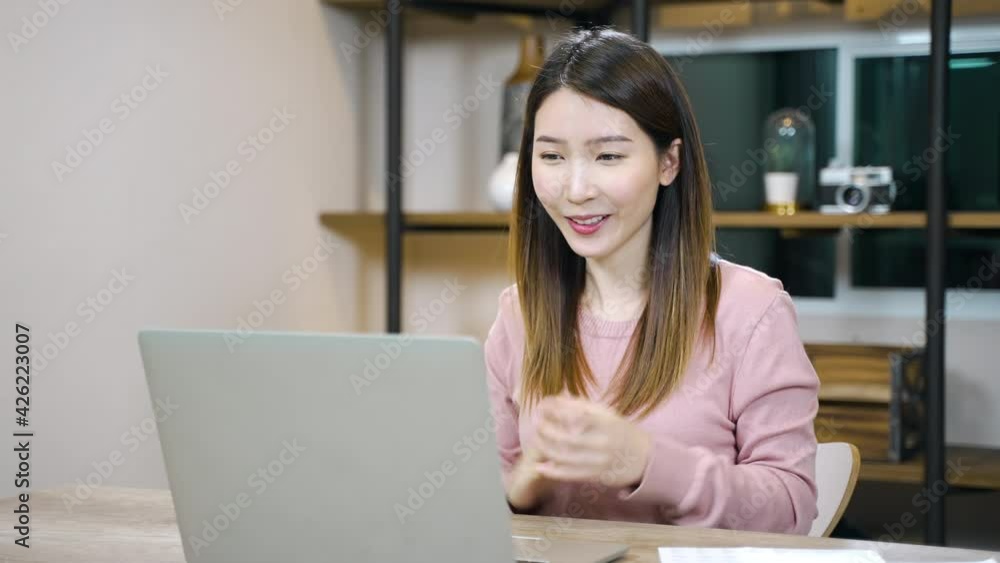 Asian woman wearing headset using laptop making video conference or online support remote working from home Asian woman wearing headset using laptop making video conference or online support remote working from home