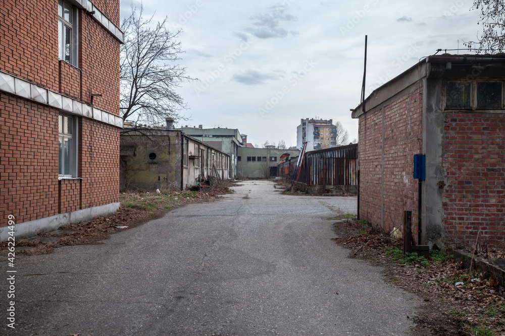 Abandoned factories and warehouses in red brick, with broken windows and crumbling walls in Eastern Europe, in Pancevo, Serbia, former Yugoslavia, during a cold winter afternoon 