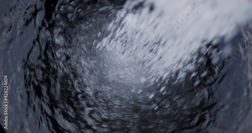 Pour Fertilizer Calcium nitrate mix in a black tank, Blurred moving water spins.