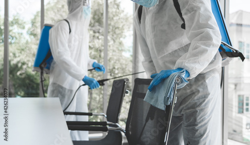 Man in virus protective suite and mask spraying alcohol cleaning covid19 infected area, Virus disinfection concept photo