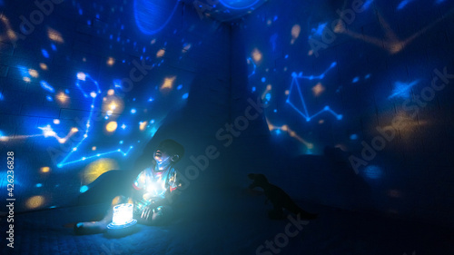 Little boyl in his room with night light projecting stars on room ceiling. Children read before bedtime. © PRASERT