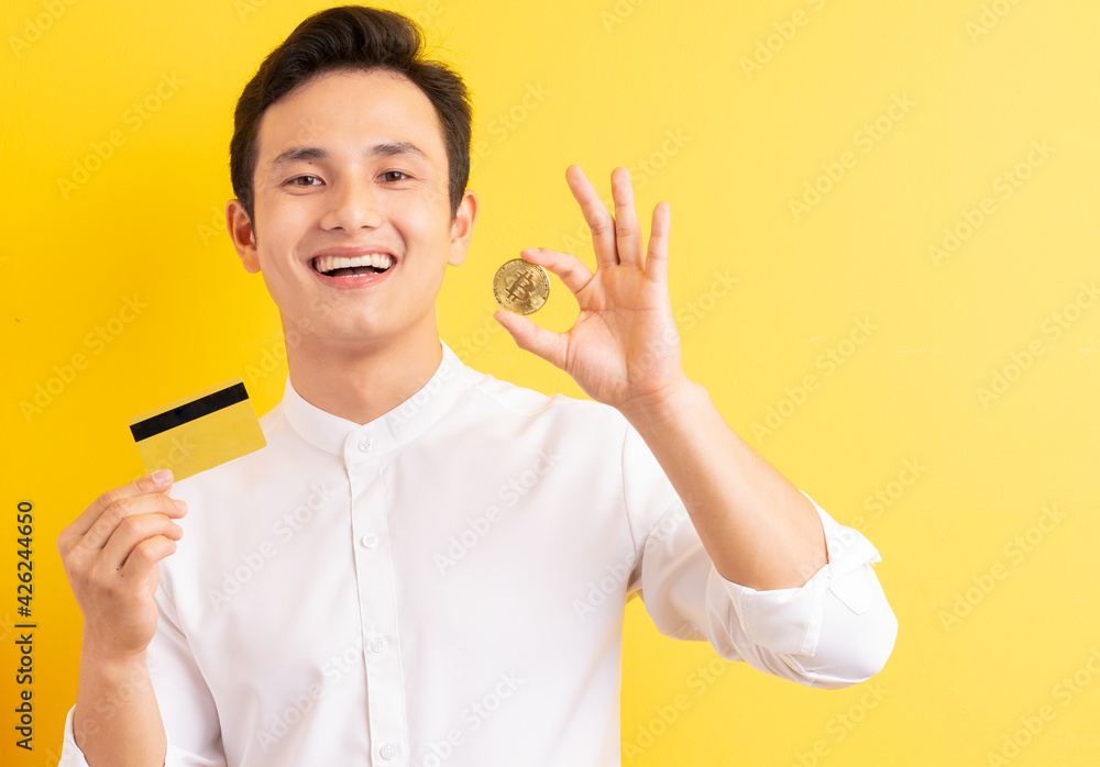 Asian businessman holding bitcoin in his hand wite happy face Asian businessman holding bitcoin in his hand wite happy face