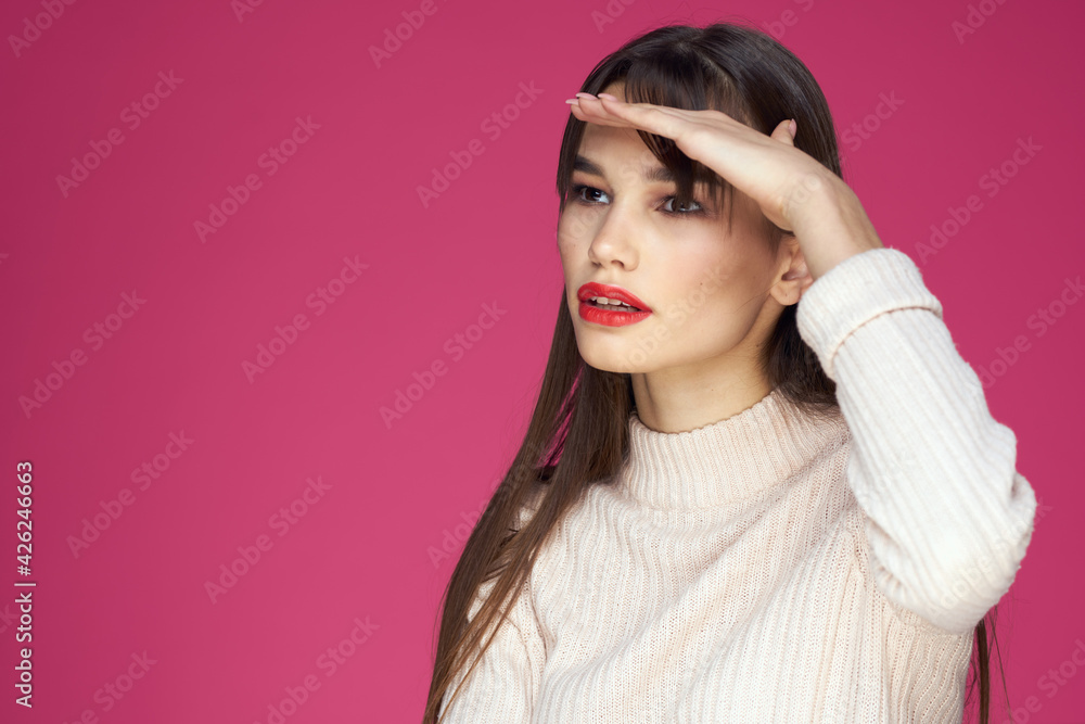 Brunette with long hair red lips cosmetics white sweater pink background cropped view Brunette with long hair red lips cosmetics white sweater pink background cropped view