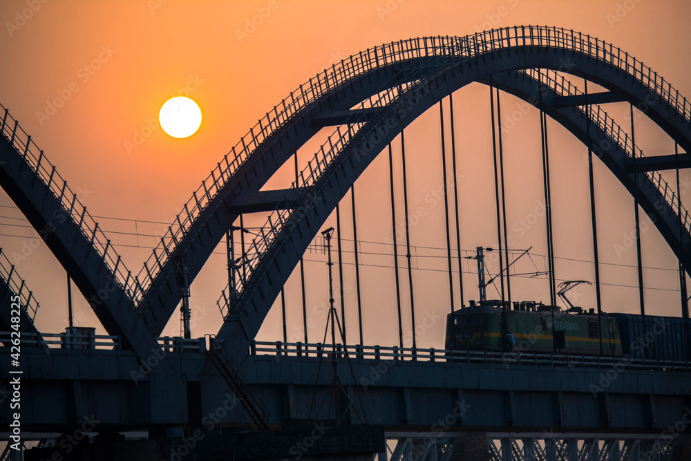 Obraz premium The Godavari Arch Bridge is a bowstring-girder bridge that spans the Godavari River in Rajahmundry, India. It is the latest of the three bridges that span the Godavari river at Rajahmundry. 