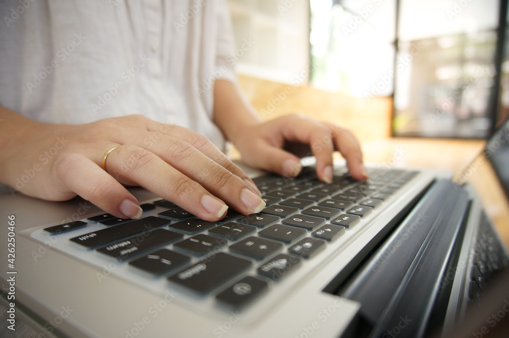 Woman working by using a laptop computer Hands typing on keyboard. writing a blog. Working at home are in finger typewriter Woman working by using a laptop computer Hands typing on keyboard. writing a blog. Working at home are in finger typewriter