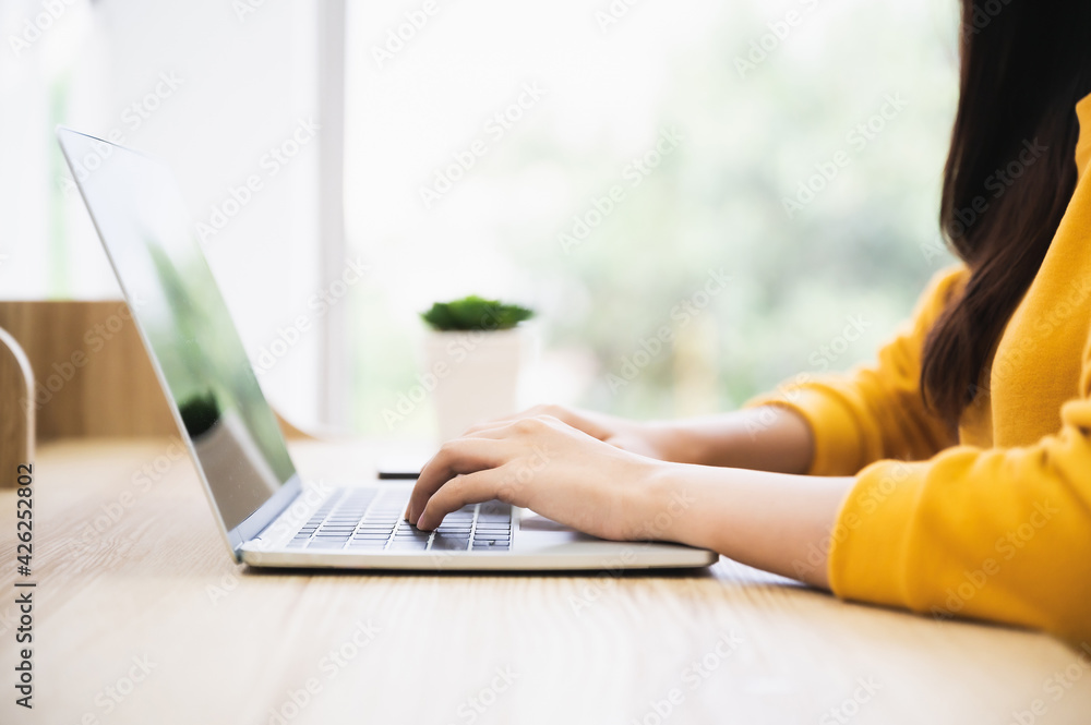 Fototapeta premium Woman using computer laptop on wood desk. She working at home