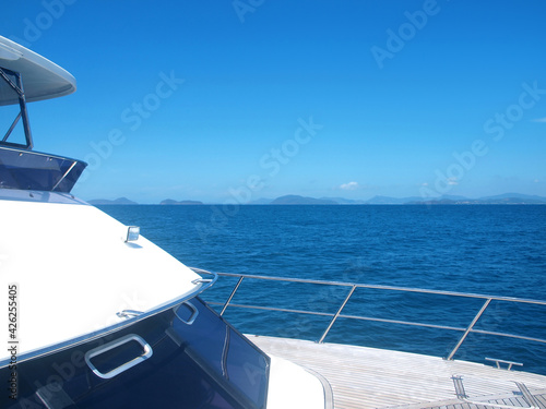 View from the luxury yacht moving on the sea to the islands and land. Blue water, clear sky. Ocean, cruise, sea trip. Popular tropical resort. Asia. Tour tourism. Ripple on the surface of water. Thai © Oxana