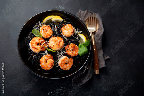 Spaghetti with shrimps and parmesan on dark background. Tasty appetizings seafood pasta.