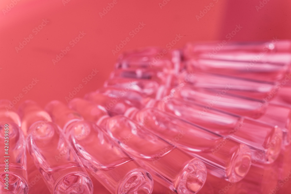 Glass medical ampoule vial for injection. Medicine is liquid sodium chloride with of aqueous solution in ampulla. Close up. Bottles ampule multicolor. Glass medical ampoule vial for injection. Medicine is liquid sodium chloride with of aqueous solution in ampulla. Close up. Bottles ampule multicolor.