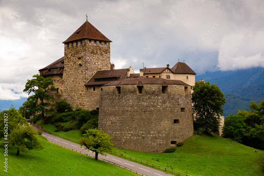 Medieval architecture, Vaduz castle with Alps mountains in clouds on background