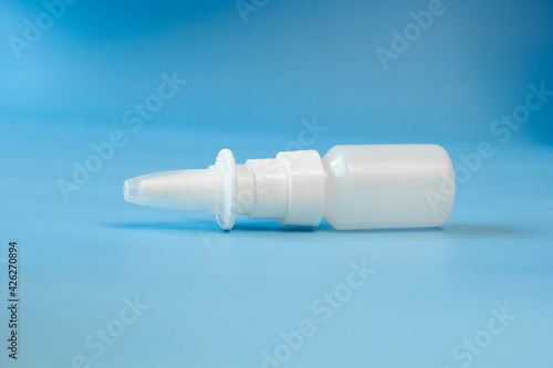 Plastic container for nose and eye drops, bottle. isolated on blue background. Place for an inscription. Copyspace