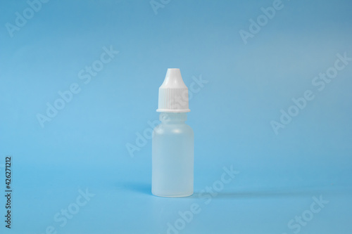 Plastic container for nose and eye drops, bottle. isolated on blue background. Place for an inscription. Copyspace