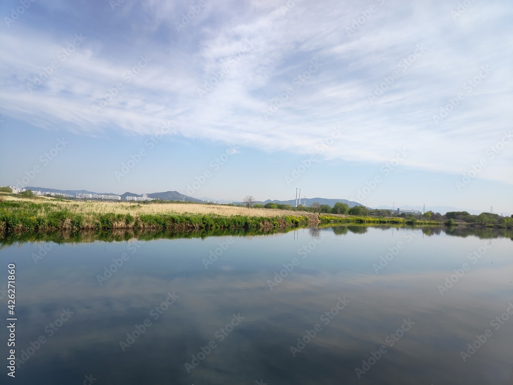 a harmonious view of the blue sky and the still river