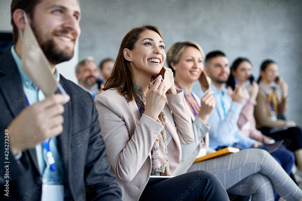 Happy businesswoman and her colleagues in board room taking off their face masks at the end of coronavirus pandemic. Happy businesswoman and her colleagues in board room taking off their face masks at the end of coronavirus pandemic.