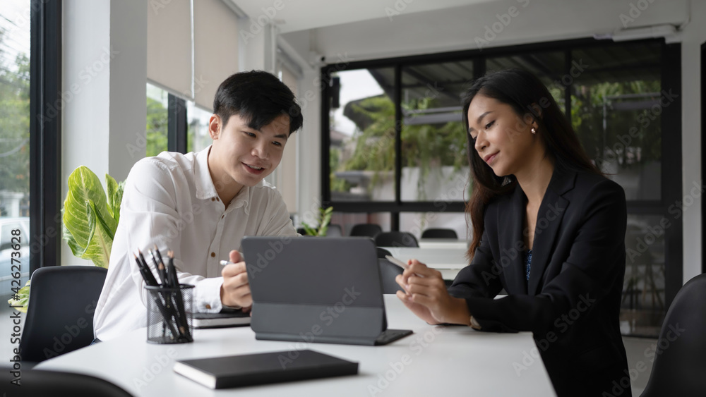 Two happy businesswoman using computer tablet and discussing business idea in modern office. Two happy businesswoman using computer tablet and discussing business idea in modern office.