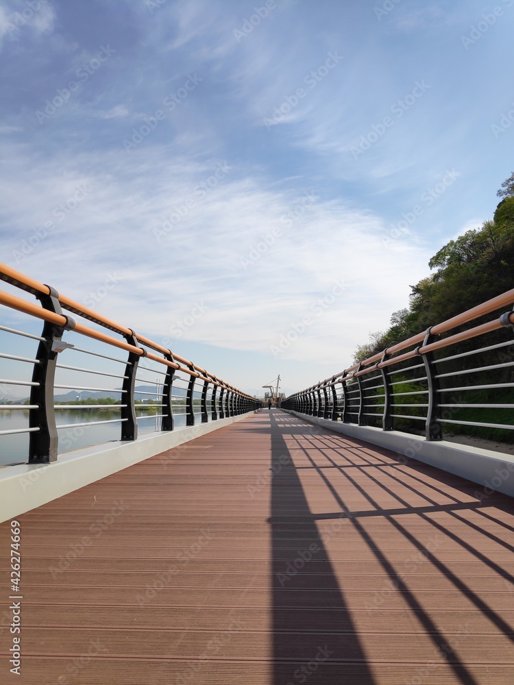 Obraz premium a walking path along the river with a view of the blue sky