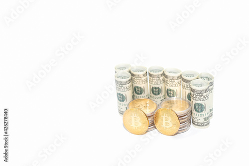 A circular roll of dollar bills with bitcoins on a white background