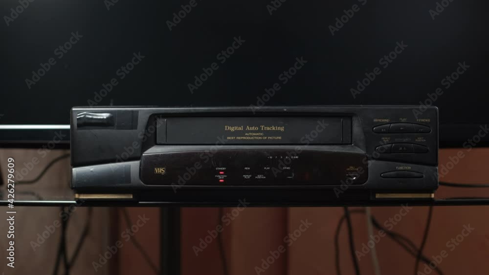 Man Ejecting VHS Tape from an Old Video Player at Home. Technology and