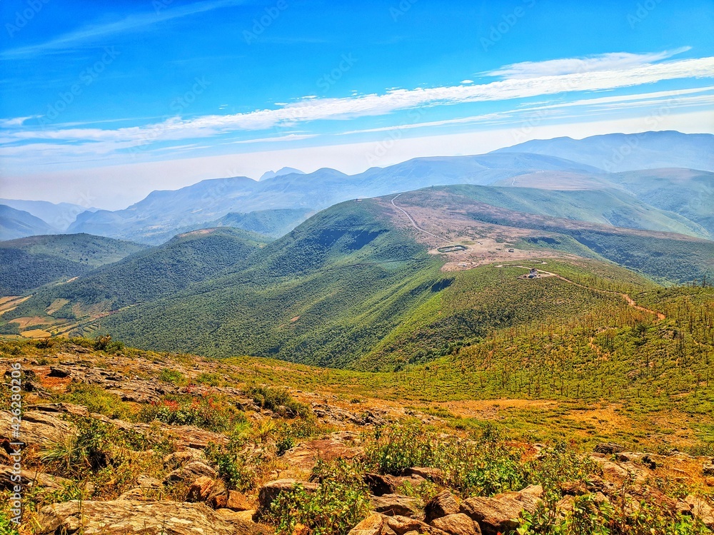 Naklejka premium Mountain range with visible silhouettes through the morning colorful fog.