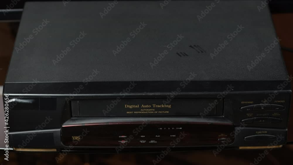 Man Ejecting Video Tape from a VHS Player at Home. Technology and