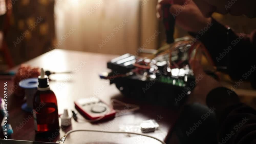 DIY, the machine on electronic control. Home experiments, robotics, smart engineer. Toy for the child. A man fixes an electronic device. soldering iron, wires, motherboard DIY, the machine on electronic control. Home experiments, robotics, smart engineer. Toy for the child. A man fixes an electronic device. soldering iron, wires, motherboard