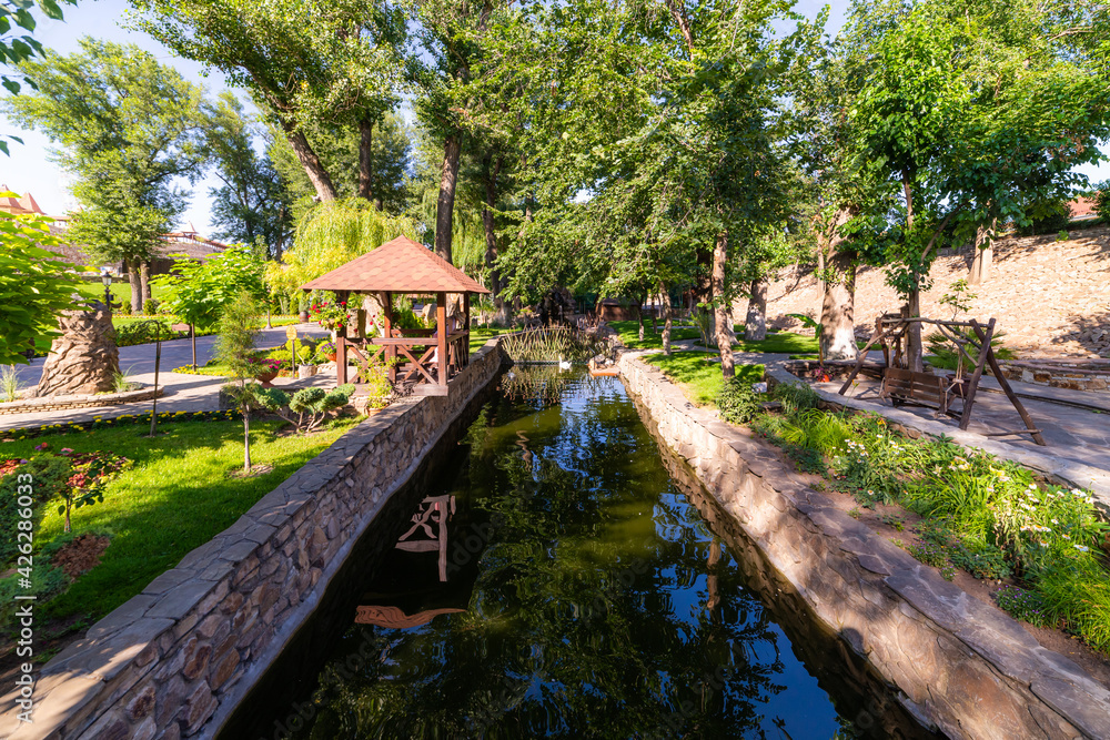 Fototapeta premium Small narrow water canal in a park