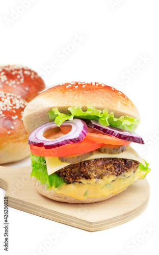 Cheeseburger on a cutting board isolated on a white background. Hamburger with cheese. Burger isolated. Tasty dinner. Vertical orientation