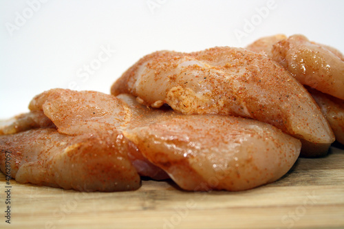 Chicken fillet pieces on a wooden board.