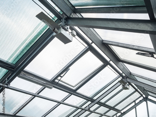 Greenhouse roof with polycarbonate windows, lamps and heating pipes to maintain temperature, light and humidity at any time of the year. Cultivation and growing of plants.