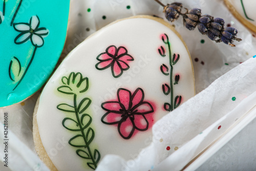Sweet, tasty and colored and painted gingerbread cookies on a light background in a light box with a sprig of lavender. The dessert is sweet. Selective focus. The concept of sweet and cooking