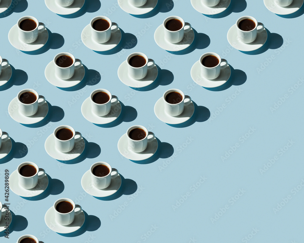 Rhythmic pattern from cups with coffee on a blue background.