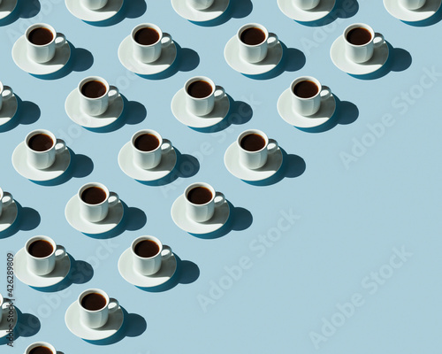 Obraz na płótnie Rhythmic pattern from cups with coffee on a blue background. w salonie