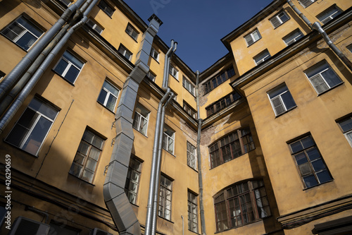 Corner panorama of an old yellow house with a ventilation system on the facade