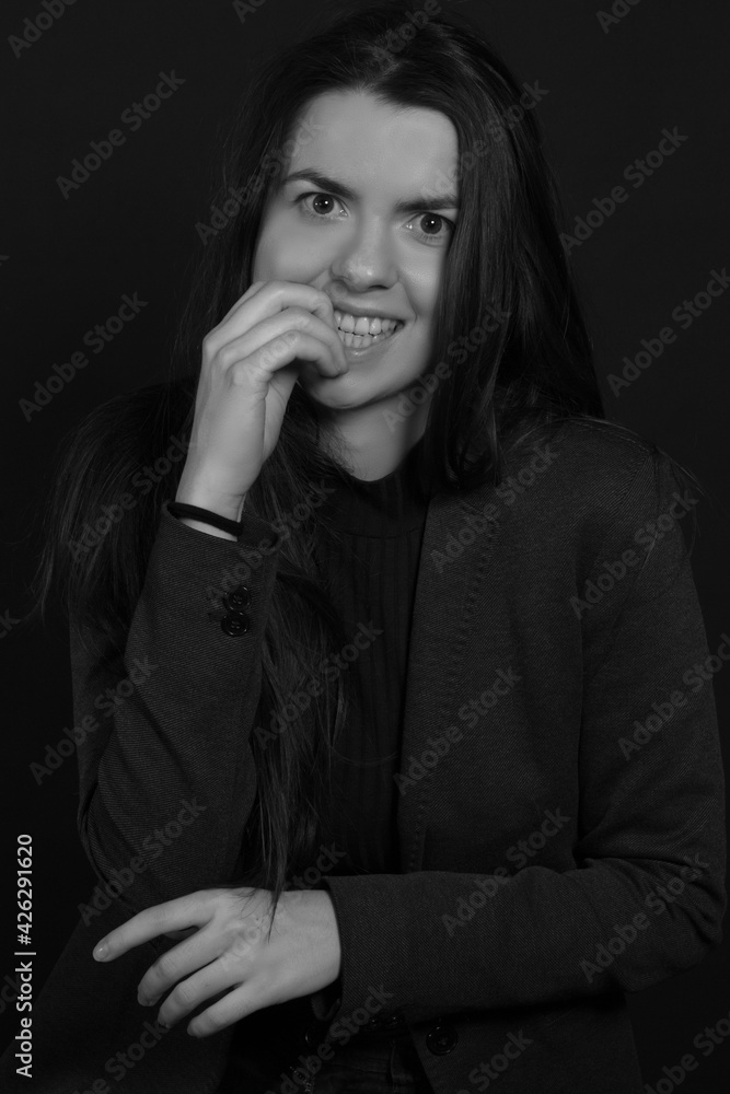 Black and white portrait of a young brunette woman in a studio on a black background Black and white portrait of a young brunette woman in a studio on a black background