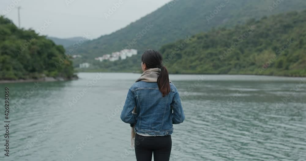 Woman enjoy the sea view and stand at the pier Woman enjoy the sea view and stand at the pier
